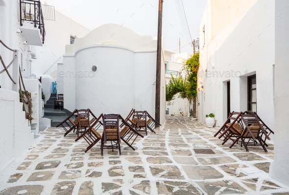 Paros island outdoor cafe tavern at Naoussa village building cobblestone yard destination Greece.