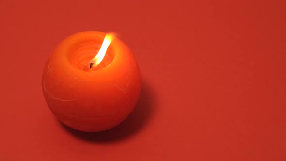 Red Round Burning Candle Isolated on Red Background