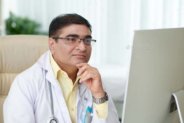Doctor Reading Article on Computer