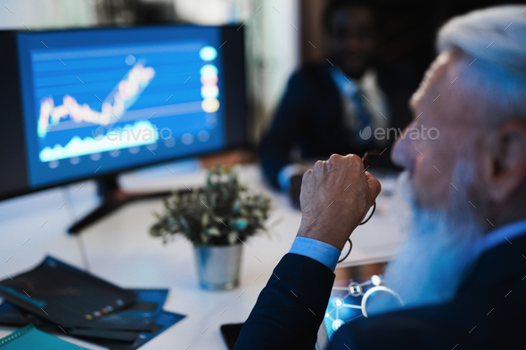 Traders people making stock market analysis inside hedge fund office - Focus on senior man arm