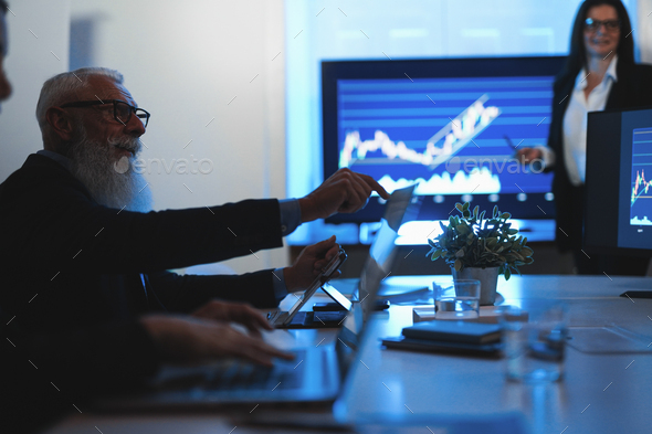 Business trader team doing stock market analysis inside hedge fund office - Focus on senior man face