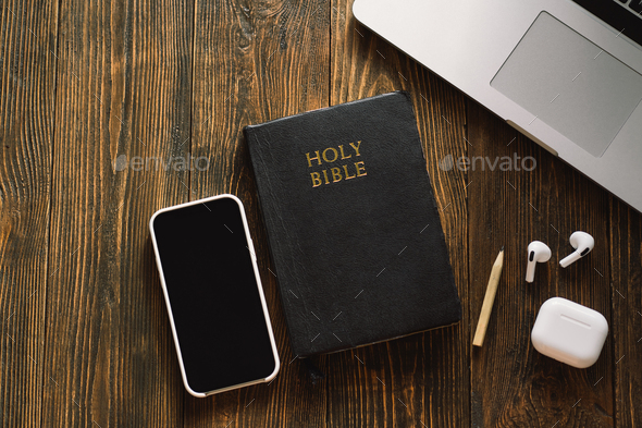 Church online Sunday new normal concept. Bible, cell phone and earbuds on a wood background.