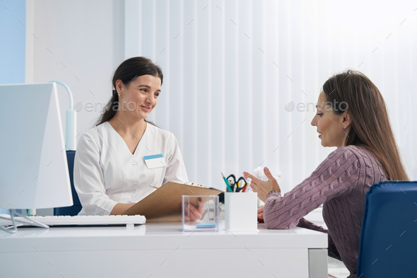 Concentrated attentive doctor conversing with her patient