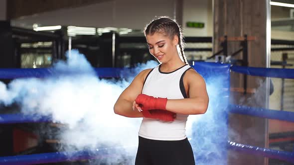 Young Boxing Woman Binds the Bandage on Hand Before Training