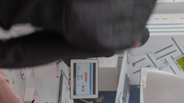 Vertical Video Businesswoman with Face Mask Analyzing Statistics with Her Collegue alt