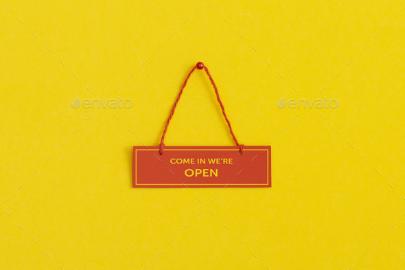 Come in we\'re open. Plate on yellow background
