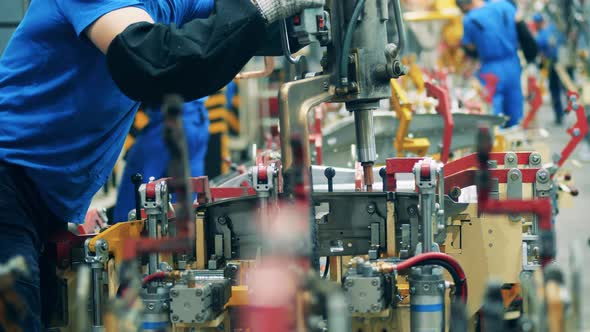 Close Up Shot of a Car Factory Worker Welding a Car Part Using a Welding Machine alt
