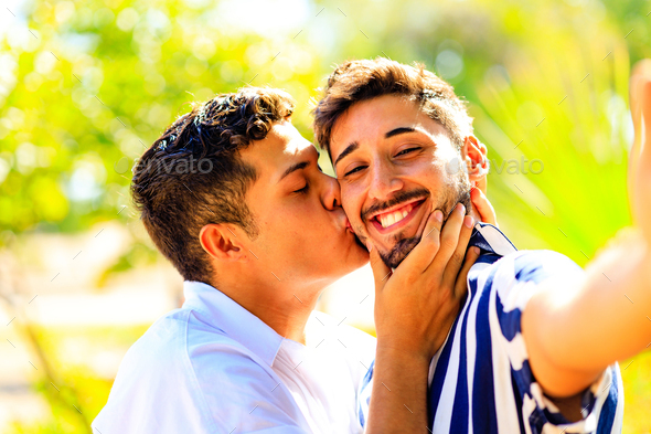 Happy gay couple taking a selfie with mobile smart phone camera in ...