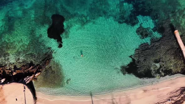Aerial View of a Beautiful White Sand Beach with Turquoise Water and Relaxing People on a Sunny Day