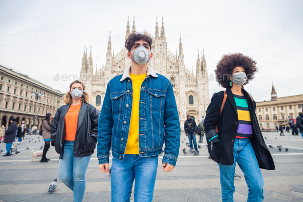 Three multiethnic friends wearing medical mask protecting from pollution and virus