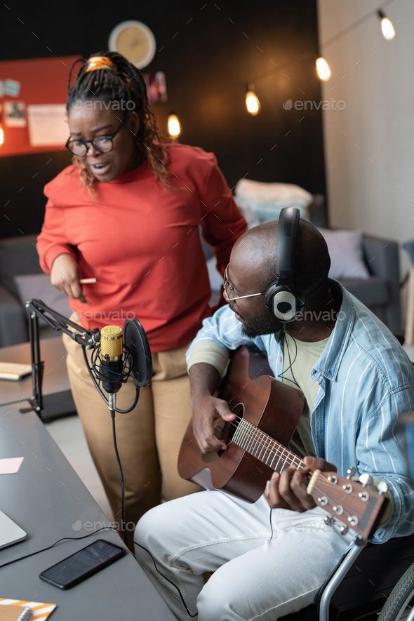 African couple recording their song at home Stock Photo by AnnaStills