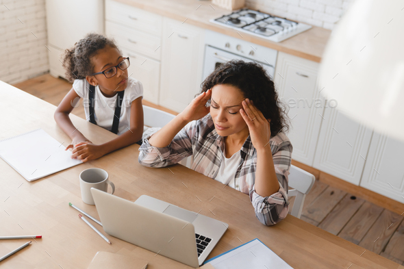 Mom working from home on maternity leave trying to concentrate while naughty daughter distracting