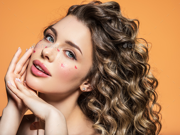 Curvy girl with trendy make-up and gorgeous curly hair posing Stock Photo