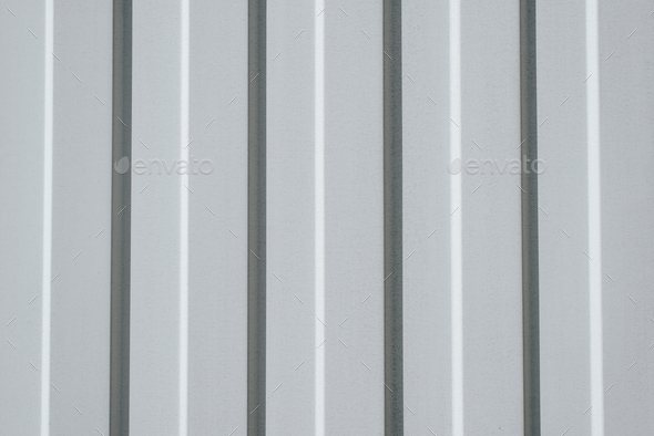 Iron, gray construction profiled sheet with vertical stripes. Closeup of a corrugated building