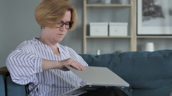 Old Senior Woman Leaving Couch after Completing Work on Laptop alt