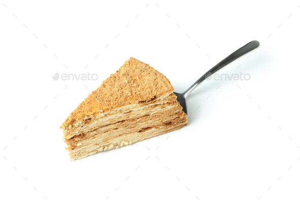Spatula with piece of honey cake isolated on white background