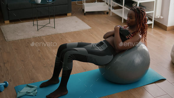 Athletic black woman doing morning fitness workout in living room