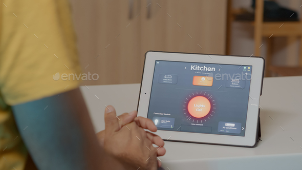 Man using voice activated smart wireless lighting app on tablet - Stock Photo - Images