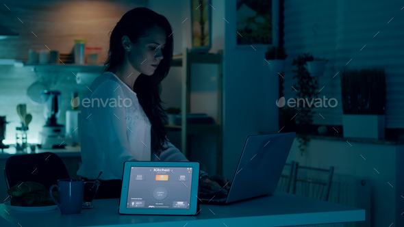 Remote woman working in modern house giving voice command to tablet - Stock Photo - Images