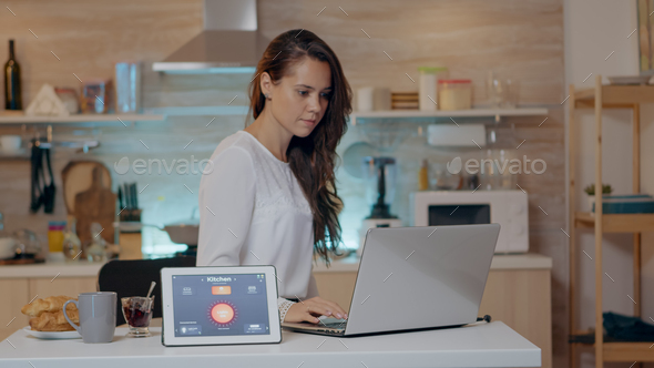 Woman using voice activated smart wireless lighting app on tablet - Stock Photo - Images