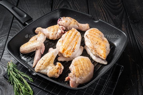 Roasted on a grill skillet chicken meat and chicken parts - drumstick, breast fillet, wing, thigh.