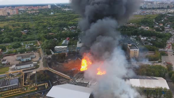Burning building of plant. Fire in the city. Aerial view. alt