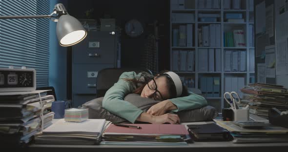 Overworked woman sleeping at her desk