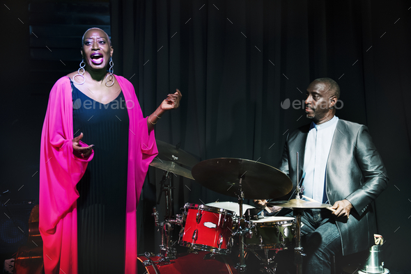 Drummer and singer performing in an event - Stock Photo - Images