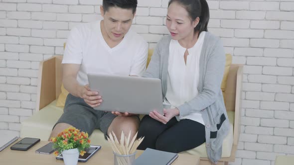 family couple husband and wife work and using laptop computer analyzing their finances alt