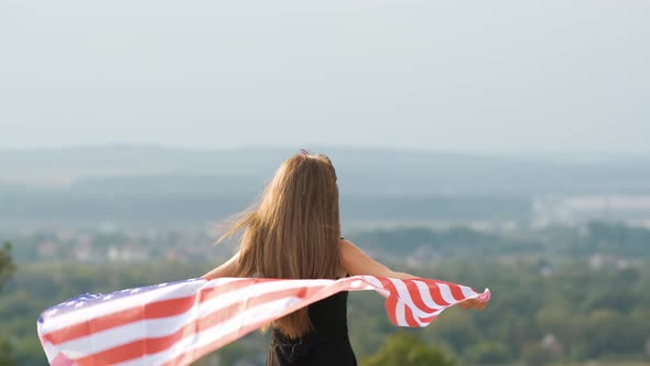 Young Happy Woman with Long Hair Holding Waving on Wind American National Flag on Her Sholders alt