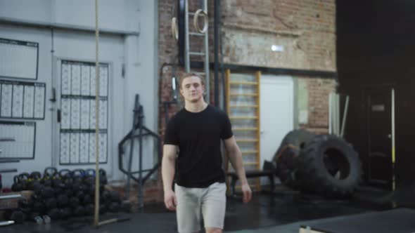 A Strong Athlete is Crossing and Looking at the Camera alt