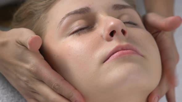 Female Masseur Massaging Client Chin, Improving Skin Tone and Muscle Contouring alt