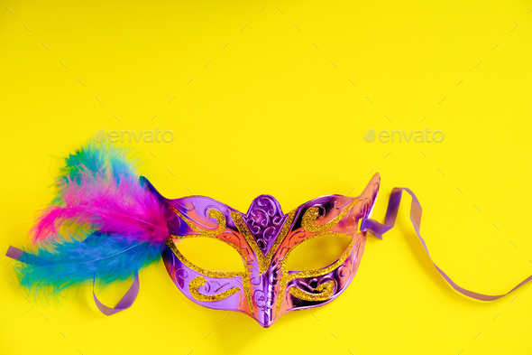 Carnival mask on yellow background. Mardi Gras concept. Fat Tuesday symbol.