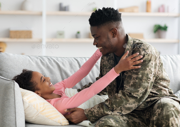 Black man soldier waking up his kid, came back home