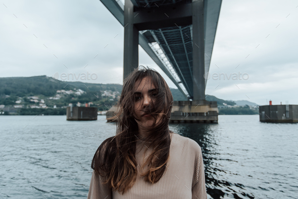 Portrait under a bridge of a woman moving his hair, time stop, mental health concept with copy space