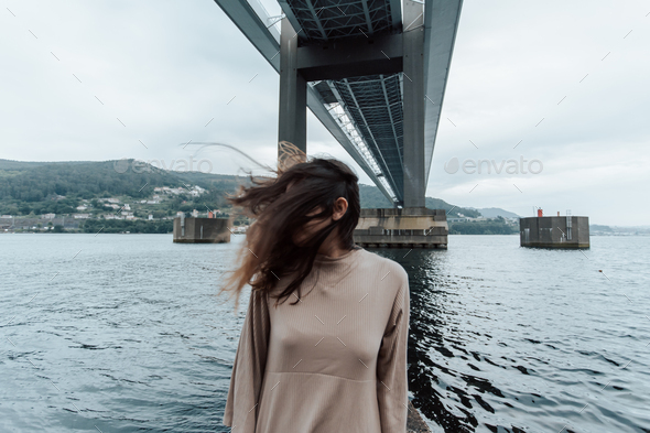 Portrait under a bridge of a woman moving his hair, time stop, mental health concept