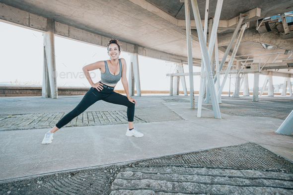 Smiling young african woman practicing yoga, stretching legs over the mat, health instructor - Stock Photo - Images