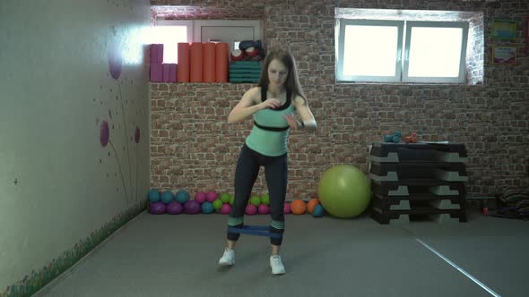 Girl Fitness Instructor Shows a Set of Exercises in the Gym