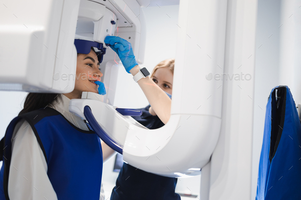 Female patient standing in x-ray machine. Teeth panoramic radiography