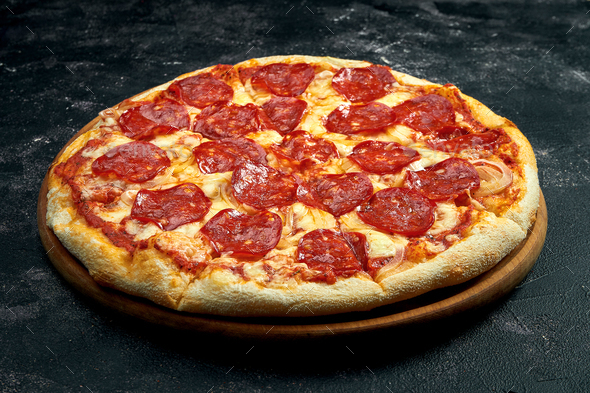 Pizza with salami pepperoni on a black stone background. 45 degree angle view