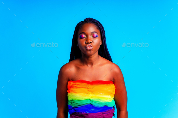 brazilian woman in multi color top blouse rainbow and make up in blue studio background
