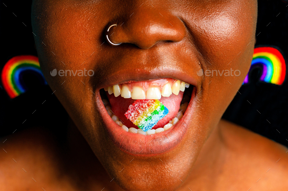 brazilian woman in multi color top blouse rainbow and make up in blue studio background