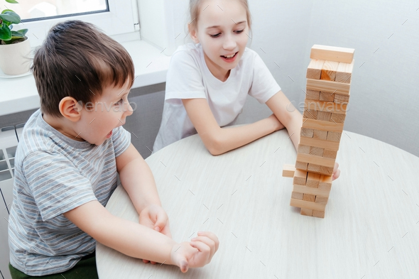 Caucasian children, boy and girl playing jenga and smiling. Block ...