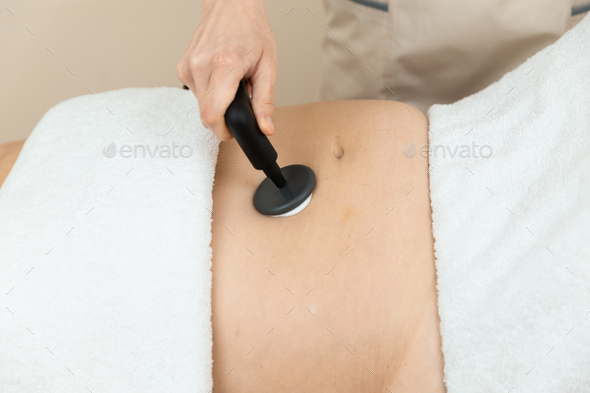 Woman receiving radiofrequency stimulation treatment for faster recovery like for inflammations - Stock Photo - Images