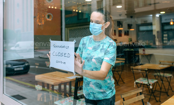 Woman placing coronavirus closure sign