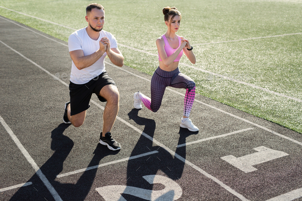 Man And A Woman Play Sports At The Stadium In The Summer, Making Lunges 