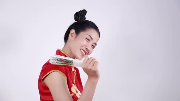 woman wearing chinese cheongsam dress and holding a chinese fan alt