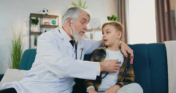 High-Skilled Respected Doctor Examining Boy Patient's Breath using stethoscope alt
