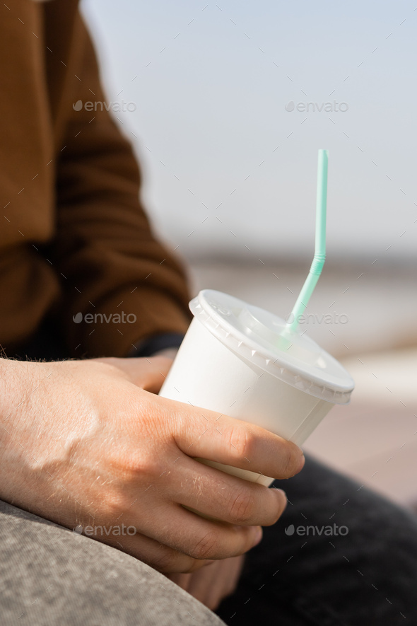Close-up of Male Hands Holding a Paper Coffee Cup and Holder for