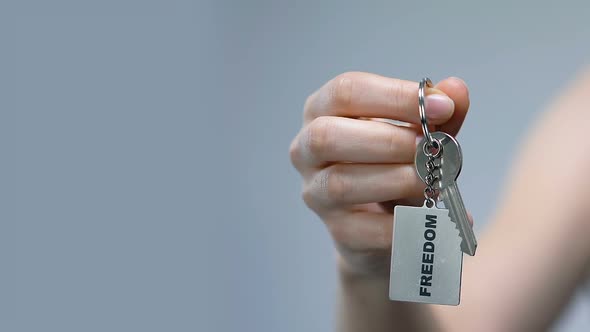 Woman Clenching Keychain With Freedom Word in Fist, Discrimination Protest alt